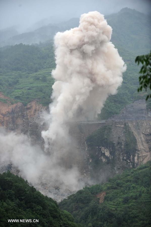 Photo taken on July 18, 2013 shows the blasting site above a barrier lake in Sanjiao Township of Hanyuan County, southwest China's Sichuan Province. The blasting is conducted to remove dangerous rocks and then dig channels to discharge the floodwater of the barrier lake. The lake was formed after a landslide and continuous rainfall, threatening residents downstream in Sichuan. (Xinhua/Xue Yubin) 
