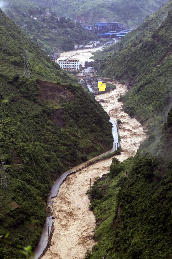 A swollen river runs through a valley, bringing damages at Daguan County in Zhaotong City, southwest China's Yunnan Province, July 18, 2013. Torrential rain over the past two days wreaked havoc in the city of Zhaotong. Three people died, 53,100 have been affected, 1,300 evacuated and thousands of hectares of crops damaged in five counties and districts in Zhaotong, said the city's flood control authorities Thursday. (Xinhua/Zhang Guangyu)