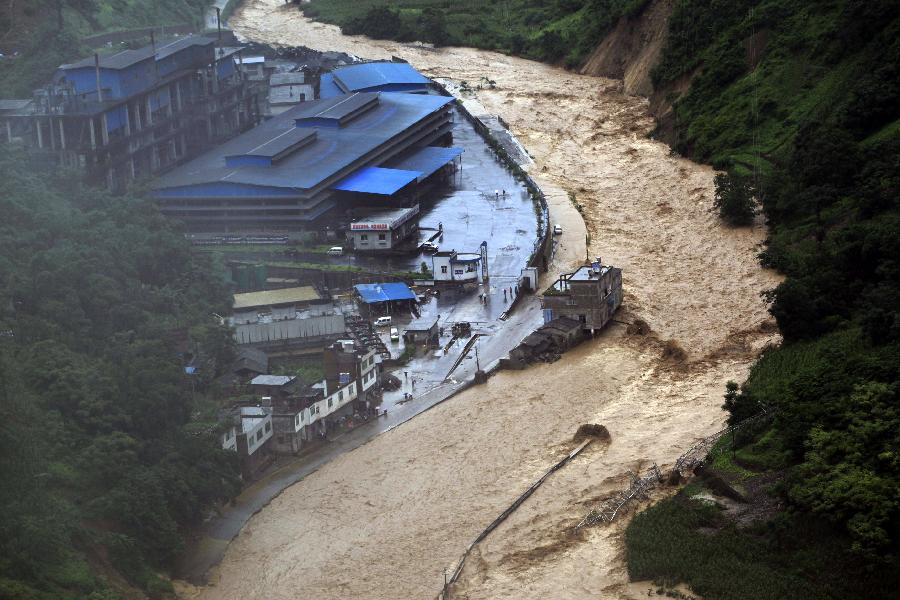 A swollen river runs through a valley, bringing damages at Daguan County in Zhaotong City, southwest China's Yunnan Province, July 18, 2013. Torrential rain over the past two days wreaked havoc in the city of Zhaotong. Three people died, 53,100 have been affected, 1,300 evacuated and thousands of hectares of crops damaged in five counties and districts in Zhaotong, said the city's flood control authorities Thursday. (Xinhua/Zhang Guangyu)