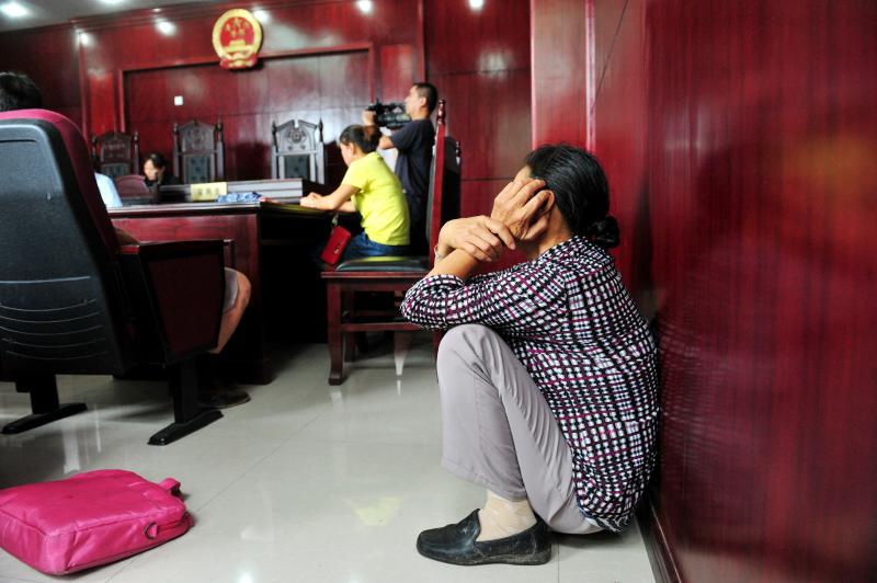 Li Lanyu's daughter in law crouches in the corner. (Photo/wccdaily)