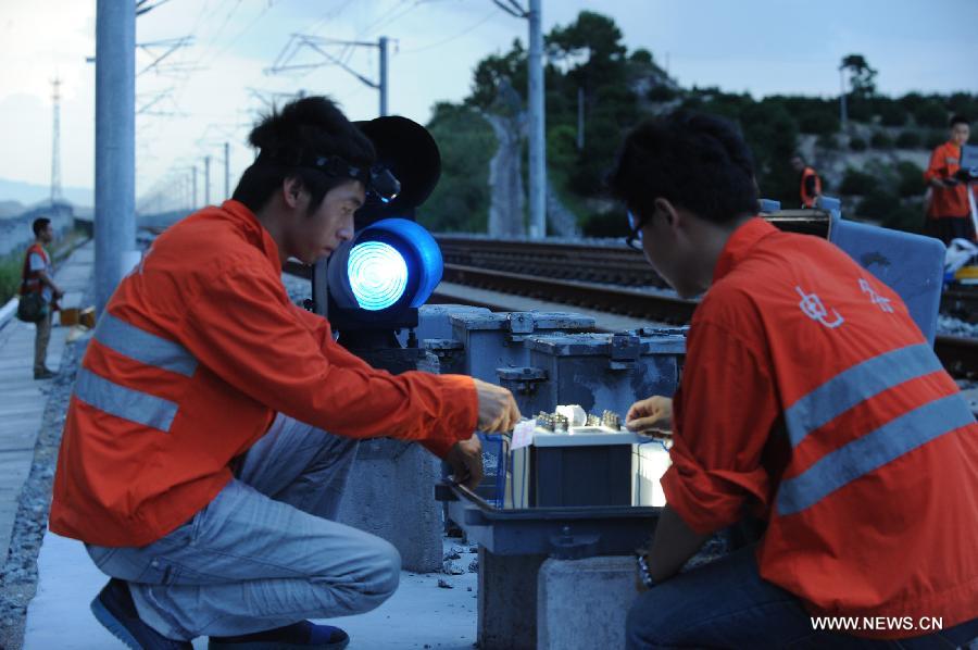 Workers work at the construction site of Xiangtang-Putian Railway, or Xiangpu Railway, July 18, 2013. The 632-kilometer-long railway, which links Xiangtang Township in Nanchang, capital of east China's Jiangxi Province, and Putian City in southeast China's Fujian Province, is expected to open to traffic by the end of this September after all debugging and commissioning finishes. The Xiangpu Railway, which will be one of the key transportation arteries for both travellers and goods in this area after it is opened to traffic, will also be the first railway running through seven districts and counties in Jiangxi and Fujian. (Xinhua/Chen Chunyuan)
