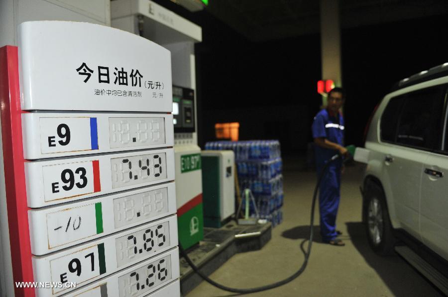 A worker of a gas station fuels a car in Baoding, north China's Hebei Province, July 20, 2013. The retail prices of gasoline and diesel of China are raised starting Saturday. The benchmark retail price of gasoline is raised by 0.24 yuan per liter and diesel by 0.26 yuan per liter. (Xinhua/Zhu Xudong)