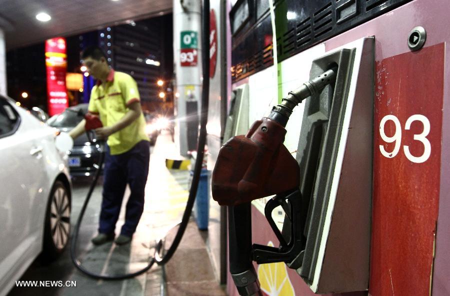 A worker of a gas station fuels a car in Shanghai, east China, July 19, 2013. The retail prices of gasoline and diesel of China are raised starting Saturday. The benchmark retail price of gasoline is raised by 0.24 yuan per liter and diesel by 0.26 yuan per liter. (Xinhua/Pei Xin)