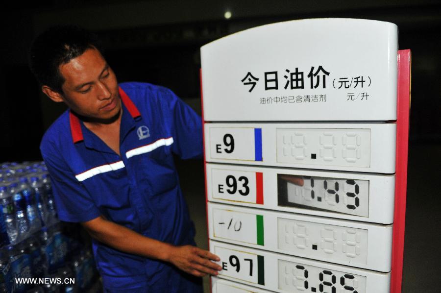 A worker of a gas station adjusts the bulletin board on fuel price in Baoding, north China's Hebei Province, July 20, 2013. The retail prices of gasoline and diesel of China are raised starting Saturday. The benchmark retail price of gasoline is raised by 0.24 yuan per liter and diesel by 0.26 yuan per liter. (Xinhua/Zhu Xudong) 