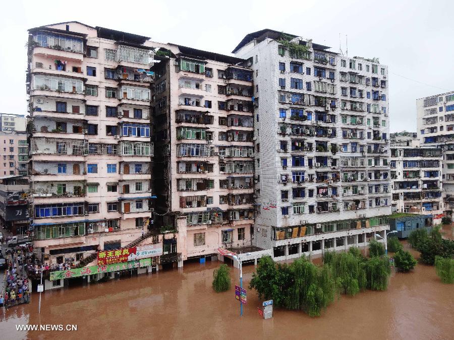 Residential buildings are flooded due to the rising water level of Qujiang River in Quxian County, southwest China's Sichuan Province, July 20, 2013. Lingering rainstorms hit the Bazhong City in the upper reaches of the Qujiang River, leading to the flood of the river. (Xinhua/Deng Liangkui)