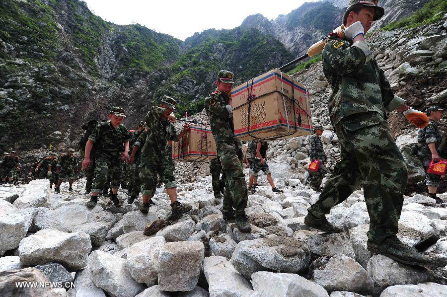 Villagers are evacuated on the restored road in Caopo Township of Wenchuan County, southwest China's Sichuan Province, July 20, 2013. The road lingking Caopo Township and outside which was badly damaged by previous mud-rock flow has been reopened on Saturday, which will facilitate future rescue work in the town.(Xinhua/He Haiyang) 