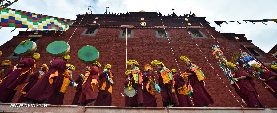Monks take part in the annual religious ritual of unfolding a huge Buddha portrait in the Gandan Temple in Lhasa, capital of southwest China's Tibet Autonomous Region, July 22, 2013. Founded in 1409 by followers of Zong Kaba, founder of the Yellow Sect of Tibetan Buddhism, the Gandan Temple is the oldest among lamaseries of the Yellow Sect. (Xinhua/Purbu Zhaxi)
