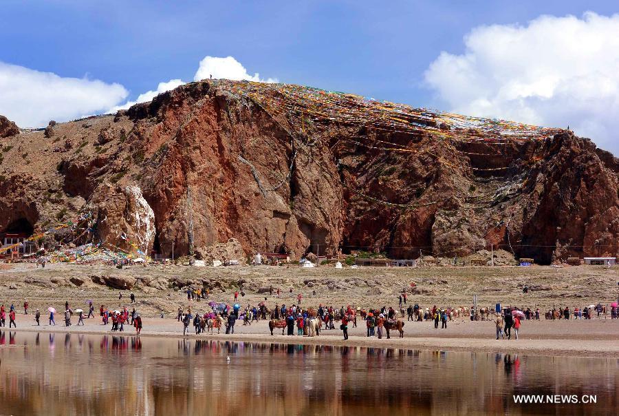 Tourists visit the Tashi Dor, a peninsula protruding into Lake Namtso in southwest China's Tibet Autonomous Region, July 19, 2013. Namtso, meaning "the heavenly lake" in Tibetan language, has become one of the preferences for a growing number of tourists to Tibet. (Xinhua/Wang Song)