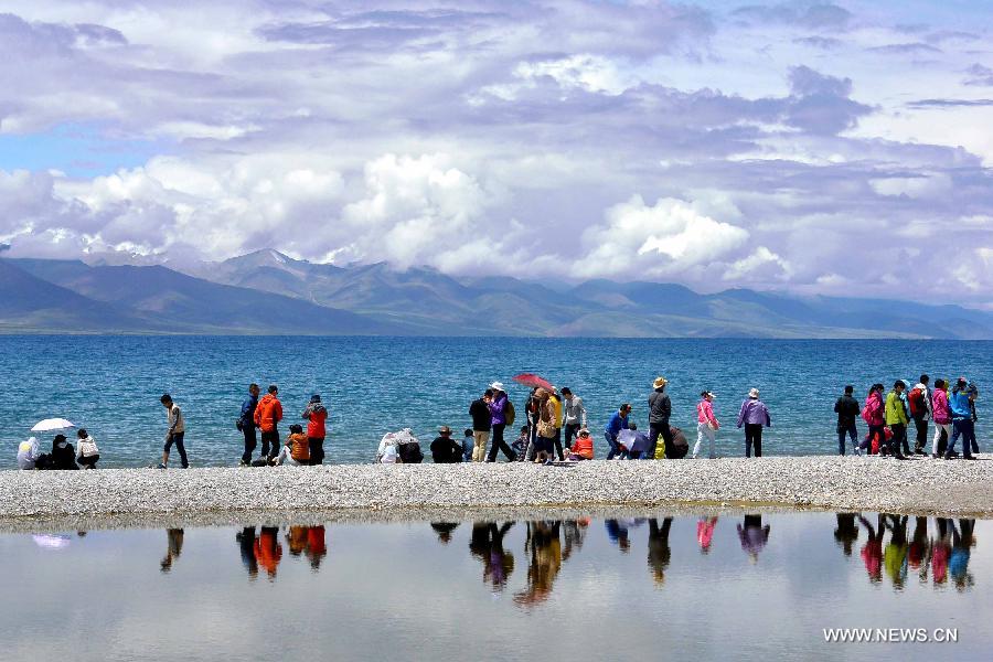 Tourists visit Lake Namtso in southwest China's Tibet Autonomous Region, July 19, 2013. Namtso, meaning "the heavenly lake" in Tibetan language, has become one of the preferences for a growing number of tourists to Tibet. (Xinhua/Wang Song)