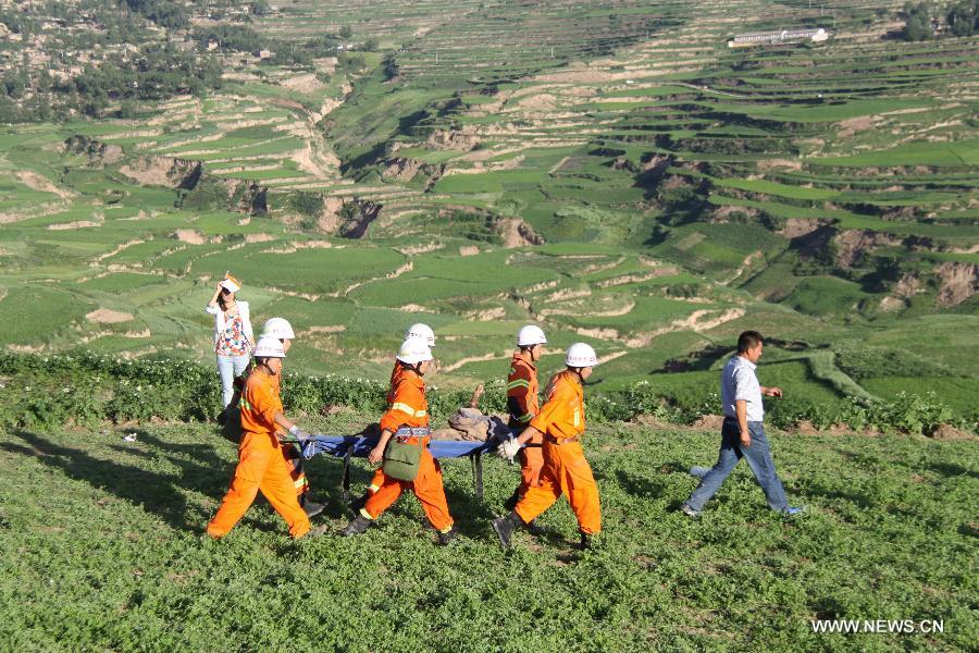 Rescuers carry a body at quake-hit Yongguang Village of Minxian County, northwest China's Gansu Province, July 22, 2013. The death toll has climbed to 89 in the 6.6-magnitude earthquake which jolted a juncture region of Minxian County and Zhangxian County in Dingxi City Monday morning. (Xinhua/Fan Yongqiang)