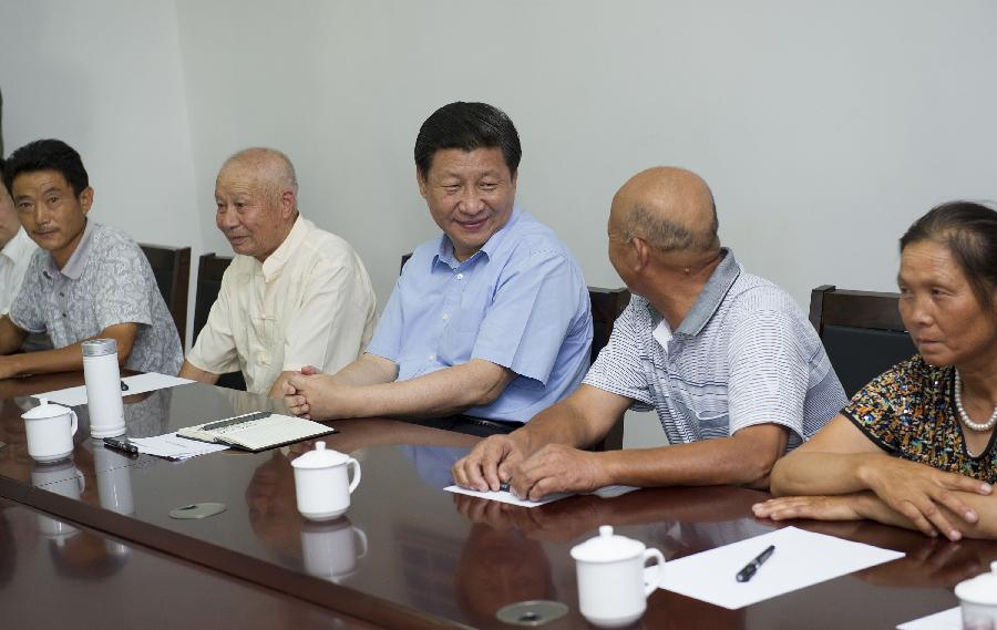 Chinese President Xi Jinping (C), who is also general secretary of the Communist Party of China (CPC) Central Committee, talks with villagers during a meeting at Dongshan Village of Changgang Township in E'zhou City, central China's Hubei Province, July 22, 2013. Xi made an inspection tour in Hubei from July 21 to July 23. (Xinhua/Huang Jingwen)