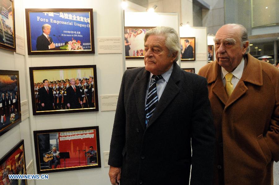 Former Uruguayan Presidents Julio Maria Sanguinetti (R) and Luis Alberto Lacalle (L) view photos in the "25 Years of Diplomatic Relations between Uruguay and China" exhibition in Montevideo, capital of Uruguay, on July 23, 2013. The photo exhibition was organized by Uruguay's Presidency, the Foreign Ministry and the Chinese Embassy to Uruguay. (Xinhua/Nicolas Celaya)
