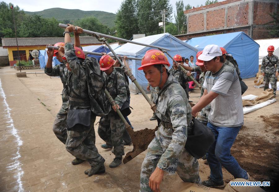 Rescuers help locals put up tents in Zhongzhai Town of the quake-stricken Minxian County, northwest China's Gansu Province, July 24, 2013. Around 150 soldiers from an engineer regiment of the Lanzhou Military Area Command have entered the quake-hit Zhongzhai Town, bringing relief materials to locals, after a 6.6-magnitude quake hit northwest China's Gansu Province on Monday morning. (Xinhua/Cao Baiming)