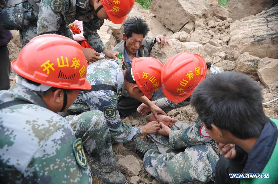Members of a medical team treat wounded villager Li Peiwen in Zhongzhai Town of quake-stricken Minxian County, northwest China's Gansu Province, July 24, 2013. Around 150 soldiers from an engineer regiment of the Lanzhou Military Area Command have entered the quake-hit Zhongzhai Town, bringing relief materials to locals, after a 6.6-magnitude quake hit northwest China's Gansu Province on Monday morning. (Xinhua/Cao Baiming) 