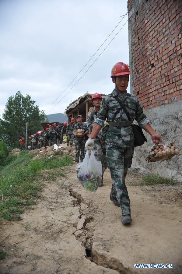 Rescuers carrying relief supplies head for Zhongzhai Town of quake-stricken Minxian County, northwest China's Gansu Province, July 24, 2013. Around 150 soldiers from an engineer regiment of the Lanzhou Military Area Command have entered the quake-hit Zhongzhai Town, bringing relief materials to locals, after a 6.6-magnitude quake hit northwest China's Gansu Province on Monday morning. (Xinhua/Cao Baiming) 