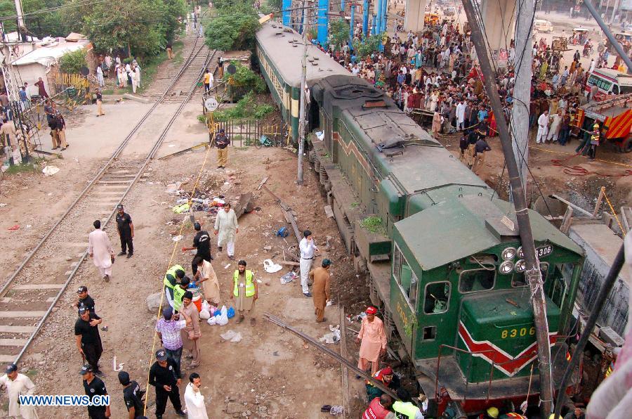 People gather at a derailed train in eastern Pakistan's Gujranwala on July 25, 2013. At least three people were killed and several others injured when a train derailed here on Thursday, local media reported. (Xinhua/Stringer)