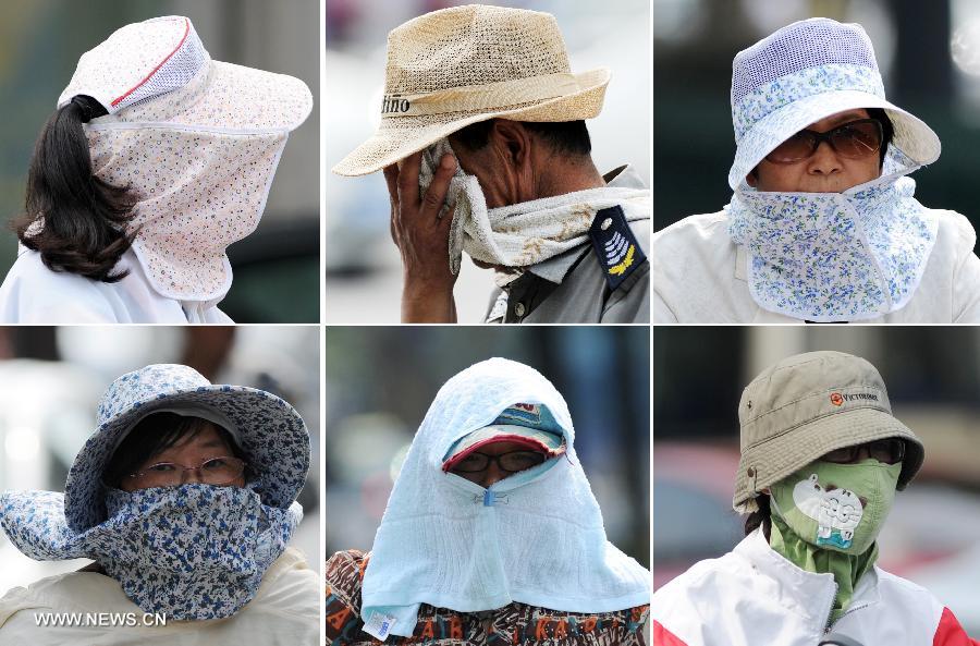 Combo photo taken on July 26, 2013 shows citizens shielding themselves from the heating sun in Hangzhou, capital of east China's Zhejiang Province. A lingering hot wave hit the city, with the highest temperature reaching above 40 degrees Celsius in these three days. (Xinhua/Ju Huanzong)