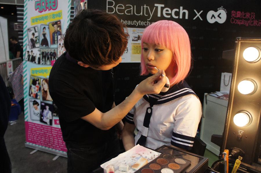 A dresser demonstrate cosplay makeups at the Animation, Comics & Games Expo in Hong Kong (ACGHK), south China, July 26, 2013. The five-day ACGHK, starting here Friday, is expected to attract some 700,000 visitors. (Xinhua/Lin Yixia) 