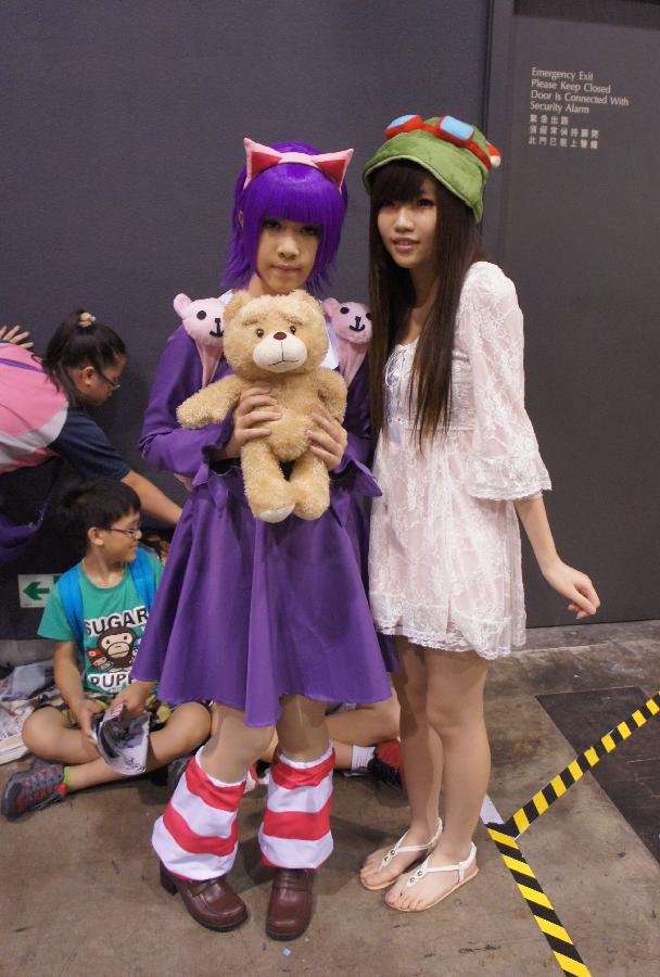 A visitor (R) poses for a photo with a cosplayer at the Animation, Comics & Games Expo in Hong Kong (ACGHK), south China, July 26, 2013. The five-day ACGHK, starting here Friday, is expected to attract some 700,000 visitors. (Xinhua/Lin Yixia) 