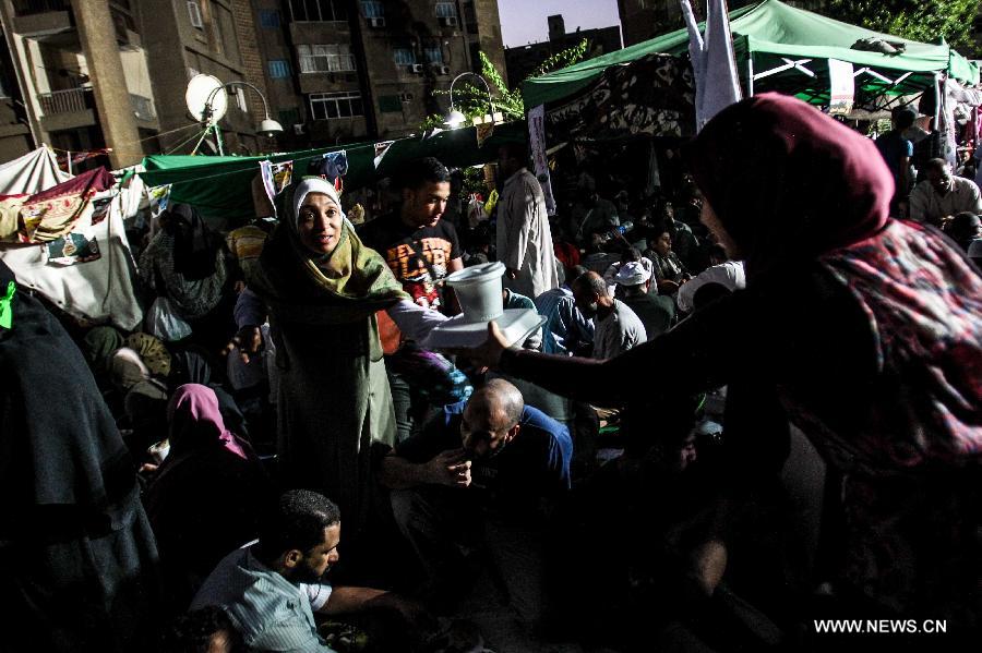 Supporters of Egypt's ousted President Mohamed Morsi have Iftar during a protest in Rabaa Al-Adaweya Square for the 29th day in row, Cairo, July 26, 2013. A top Egyptian court has ordered the detention of ousted Islamist-oriented President Mohamed Morsi for 15 days for investigations over charges of spying and jailbreak, official media reported Friday. (Xinhua/Amru Salahuddien) 