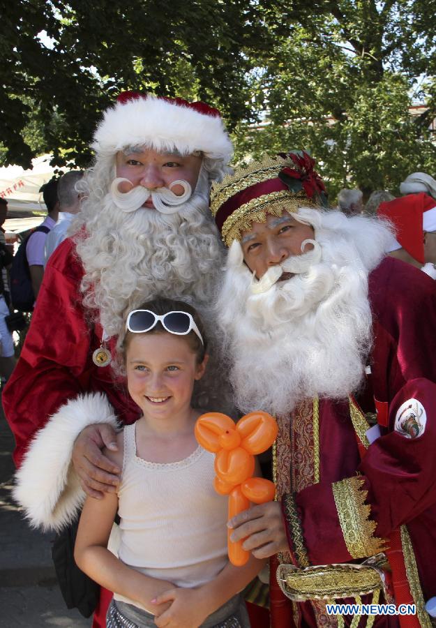 Santa Johnny (L), from China's Hong Kong, poses with his colleague and a local girl after he won the "World Best Santa Claus" in the annual World Santa Claus Congress in Copenhagen, Denmark, July 24, 2013. (Xinhua/Yang Jingzhong)
