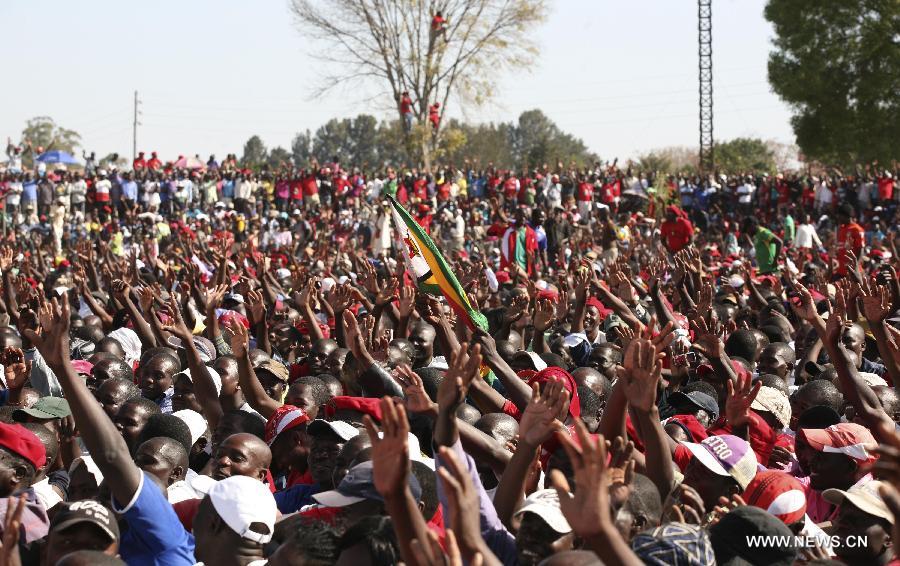 People gather at a campaign rally of presidential election candidate Morgan Tsvangirai in Chitungwiza of Harare, capital of Zimbabwe, July 28, 2013. Zimbabweans are expected to vote on July 31 to choose a president, legislators, and local councilors. Incumbent President Robert Mugabe and Prime Minister Morgan Tsvangirai are considered the main contenders for the presidency. (Xinhua/Stringer) 