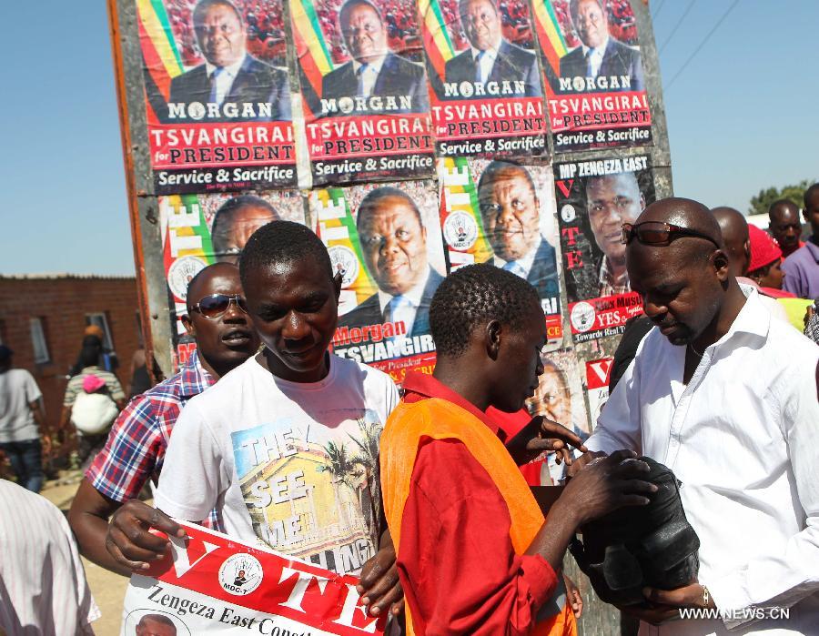 People gather at a campaign rally of presidential election candidate Morgan Tsvangirai in Chitungwiza of Harare, capital of Zimbabwe, July 28, 2013. Zimbabweans are expected to vote on July 31 to choose a president, legislators, and local councilors. Incumbent President Robert Mugabe and Prime Minister Morgan Tsvangirai are considered the main contenders for the presidency. (Xinhua/Meng Chenguang) 