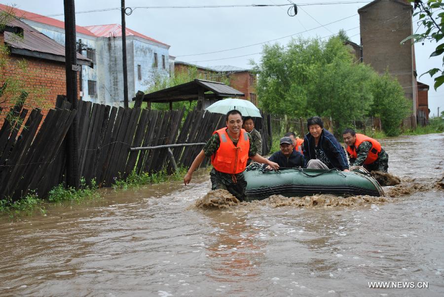 Rescuers transfer trapped residents in flood-hit Genhe City, Hulun Buir, north China's Inner Mongolia Autonomous Region, July 28, 2013. Rainstorm-triggered flood hit the city on Sunday. (Xinhua/Feng Changcai)