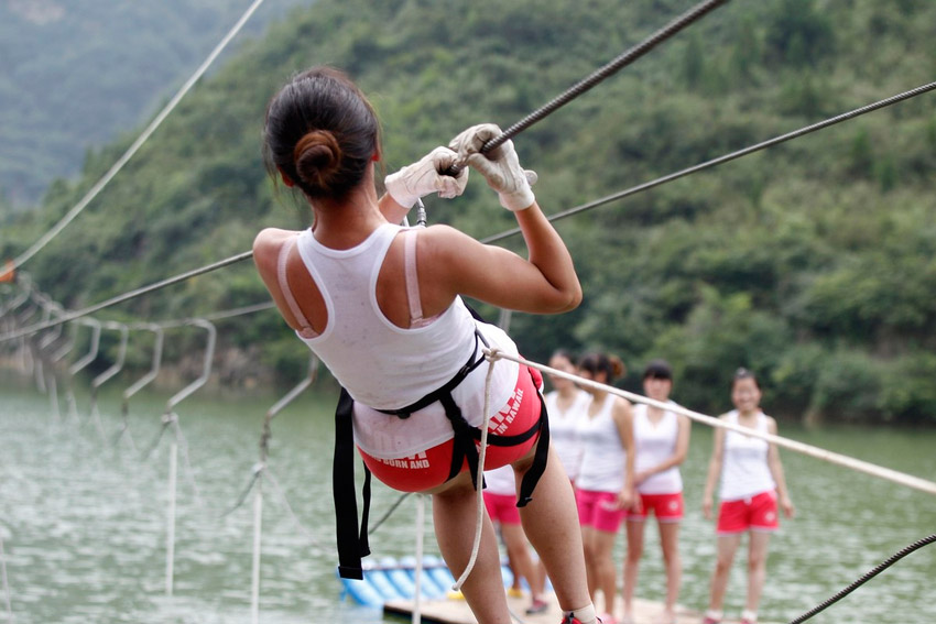 A woman takes her lifeguard training on a cable line in Yuxi Grand Canyon, central China’s Henan province on July 25, 2013. (Photo/people.com)