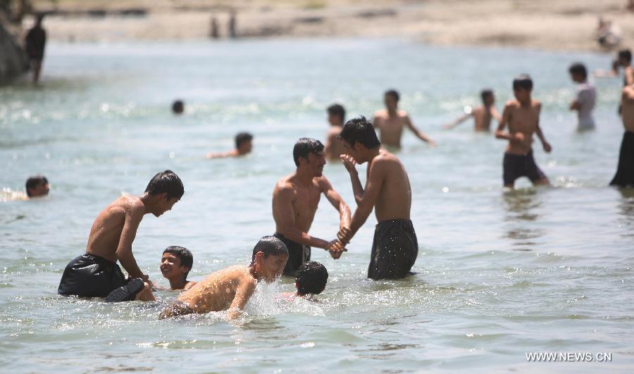 Afghans cool themselves in a canal in Parwan province of Afghanistan on July 29, 2013. (Xinhua/Ahmad Massoud)