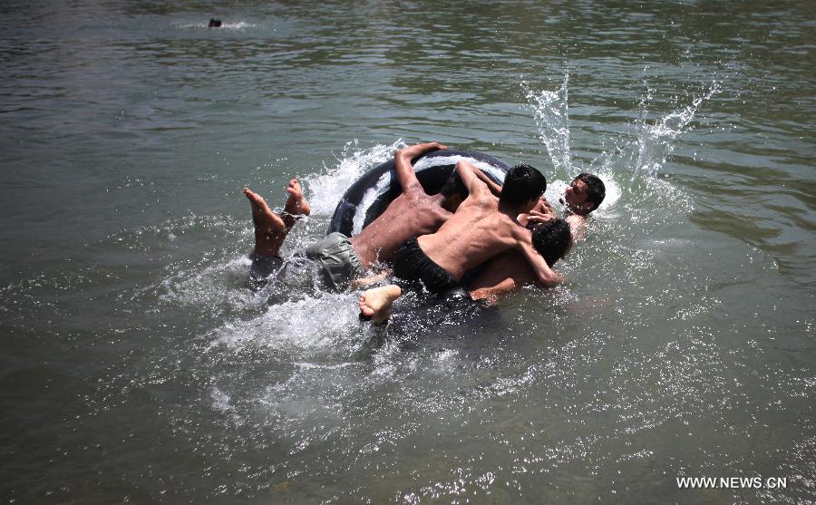 Afghans play water in a canal in Parwan province of Afghanistan on July 29, 2013. (Xinhua/Ahmad Massoud)