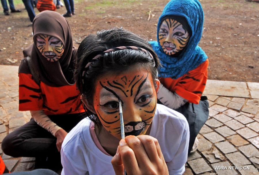 A volunteer wears make-up to attend an activity marking the Global Tiger Day 2013 in Jakarta, Indonesia, July 29, 2013. The Global Tiger Day aims to promote the protection of the habitat of Sumatran tigers and increase awareness of tiger conservation in Indonesia. (Xinhua/Agung Kuncahya B.)