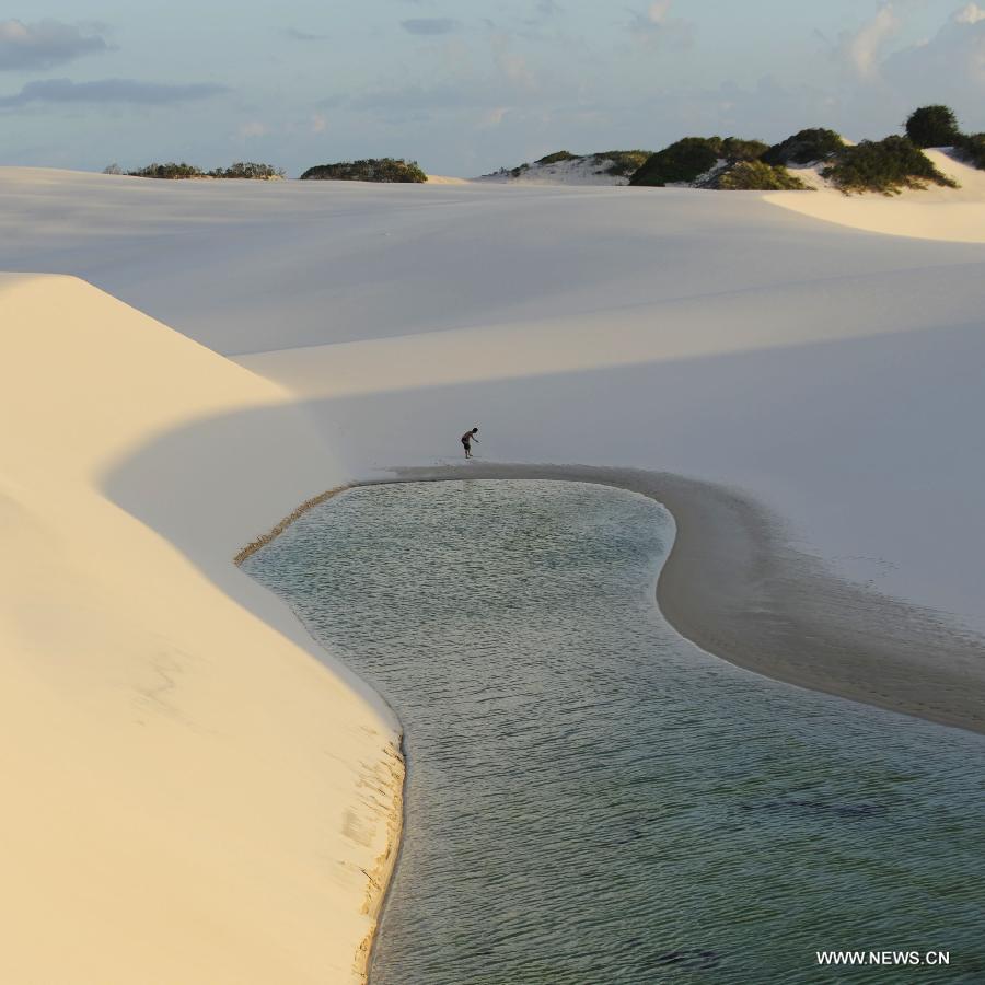 A tourist visits Lencois Maranhenses National Park located in northeast Brazil's Maranhao state, July 28, 2013. At the end of rain season every year, crystal clear lagoons form in the desert here.(Xinhua/Weng Xinyang)