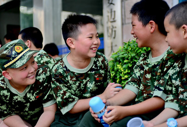 Children laugh during a break from military training in Fuqing, July 29, 2013. [Photo/Xinhua]