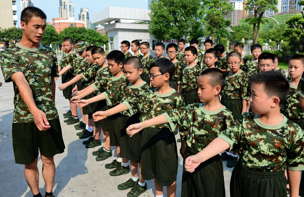 Primary school students undertake military training at a border troop camp in Fuqing, East China's Fujian province, July 29, 2013. Some 120 students in Fuqing will take part in the one-week military training during the summer vacation. [Photo/Xinhua]