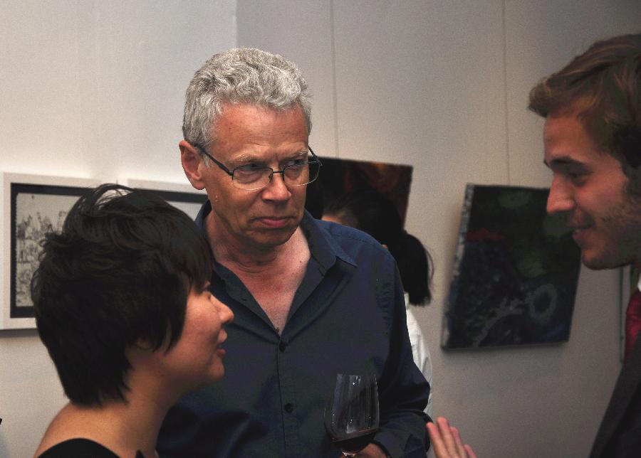 French artist Francois Bossiere (C) talks with visitors at the exhibition "The Strength of Natural Impulses" in Beijing, capital of China, July 30, 2013. Jointly contributed by French artist Francois Bossiere and four Chinese artists Zhang Sen, Zhang Yuqing, Sun Qianwei and Xie Hong, the exhibition concerned with visual art will be held from July 30 to Aug. 6 in Beijing. (Xinhua/Wang Jingqiang) 