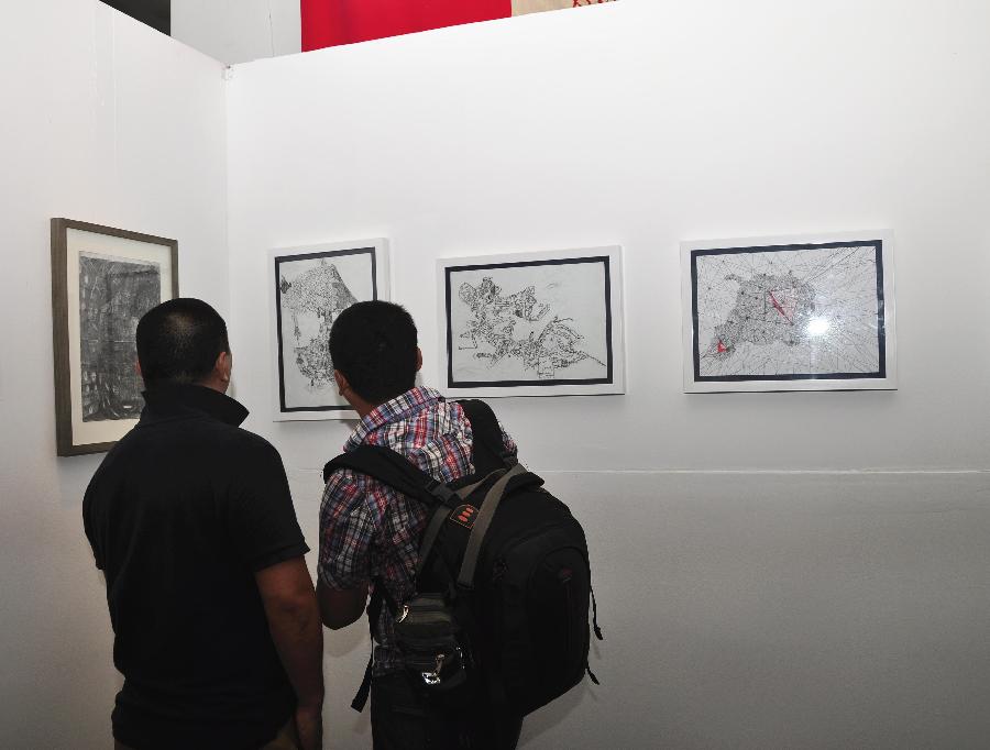 Visitors view art works at the exhibition "The Strength of Natural Impulses" in Beijing, capital of China, July 30, 2013. Jointly contributed by French artist Francois Bossiere and four Chinese artists Zhang Sen, Zhang Yuqing, Sun Qianwei and Xie Hong, the exhibition concerned with visual art will be held from July 30 to Aug. 6 in Beijing. (Xinhua/Wang Jingqiang) 