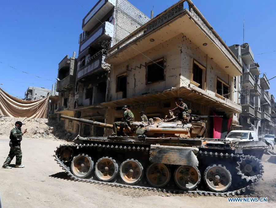 Soldiers of the Syrian army in a tank are seen in the street of al-Khalidieh district in central Homs province, Syria, July 30, 2013. The Syrian army announced Monday that its troops successfully regained full control over the strategic al-Khalidieh district in central Homs province after a series of precise operations there, according to the state-TV. (Xinhua/Zhang Naijie)