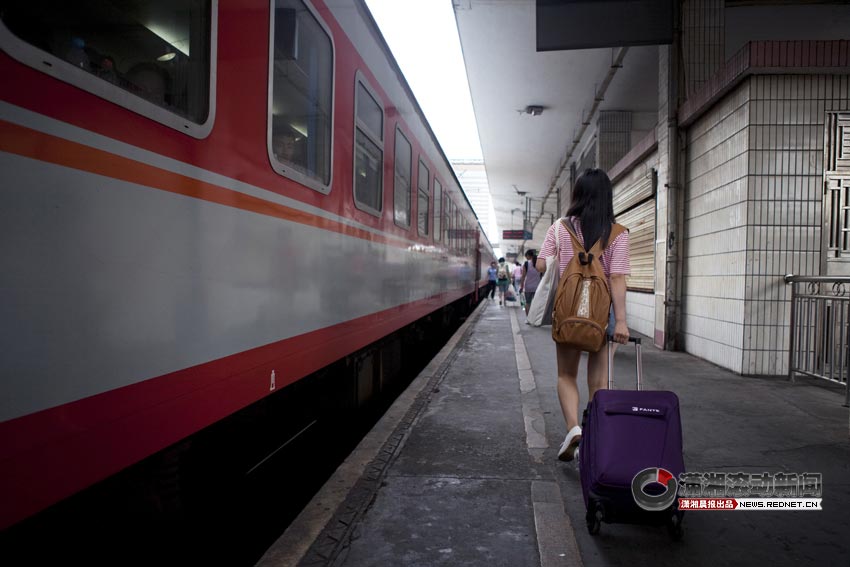 Wu Jia walks to the train home, along with her luggage, June 25, 2013. (XiaoXiang Morning Herald/Jiang Limei)