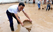 People clean silt after heavy rainfall in NW China