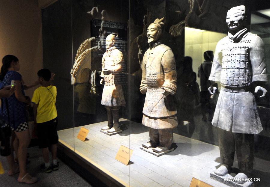Tourists visit the terracotta warriors and horses at the Emperor Qinshihuang's Mausoleum Site Museum in Xi'an, capital of Northwest China's Shaanxi province, Aug 20, 2013. The museum witnessed a tourism peak since August.[Photo/Xinhua]