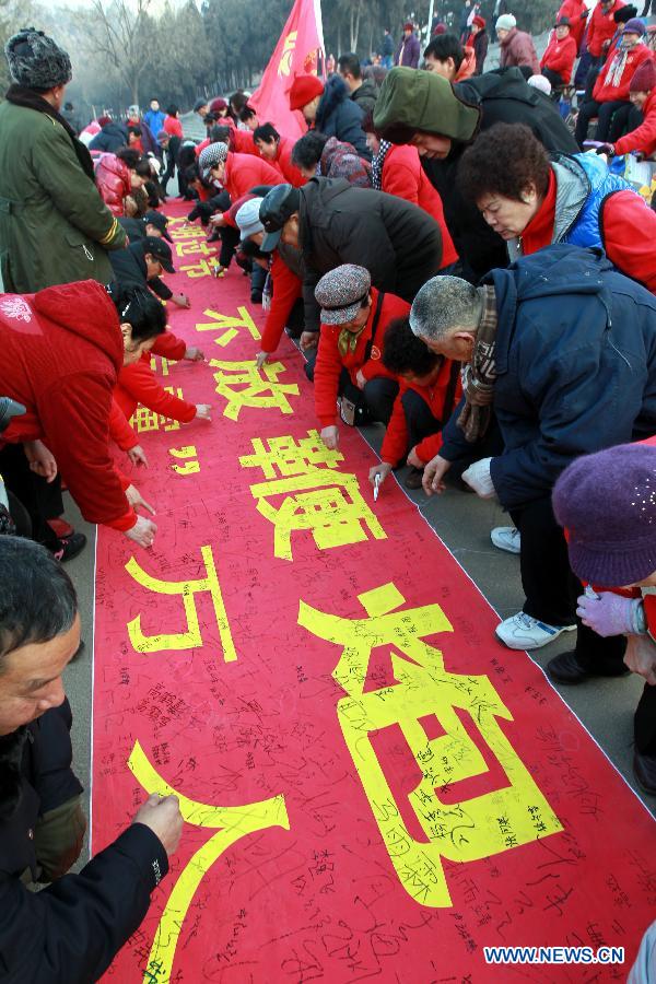 People sign the banner calling for a fireworks-free Spring Festival in Jinan, capital of east China's Shandong Province, Jan. 25, 2014. The Chinese Spring Festival, or lunar New Year, is traditionally celebrated with fireworks, which cause serious air pollution. A number of Jinan citizens called Saturday on others to stop exploding fireworks during the Spring Festival starting on Jan. 31 this year to protect the environment. (Xinhua/Lyu Chuanquan)