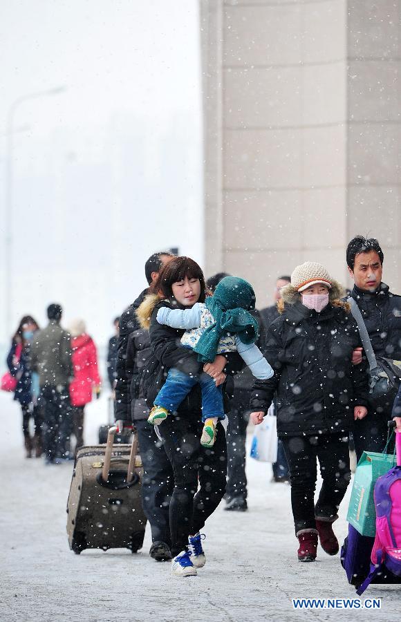 Passengers walk towards the Yinchuan Railway Station in snow in Yinchuan, capital of northwest China's Ningxia Hui Autonomous Region, Feb. 6, 2014. With the Spring Festival coming to an end, people started to leave their hometowns for the workplaces. (Xinhua/Peng Zhaozhi)