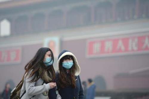 Two pedestrians wearing respirators walk on a street in Beijing, capital of China, Feb. 21, 2014. (Xinhua Photo)