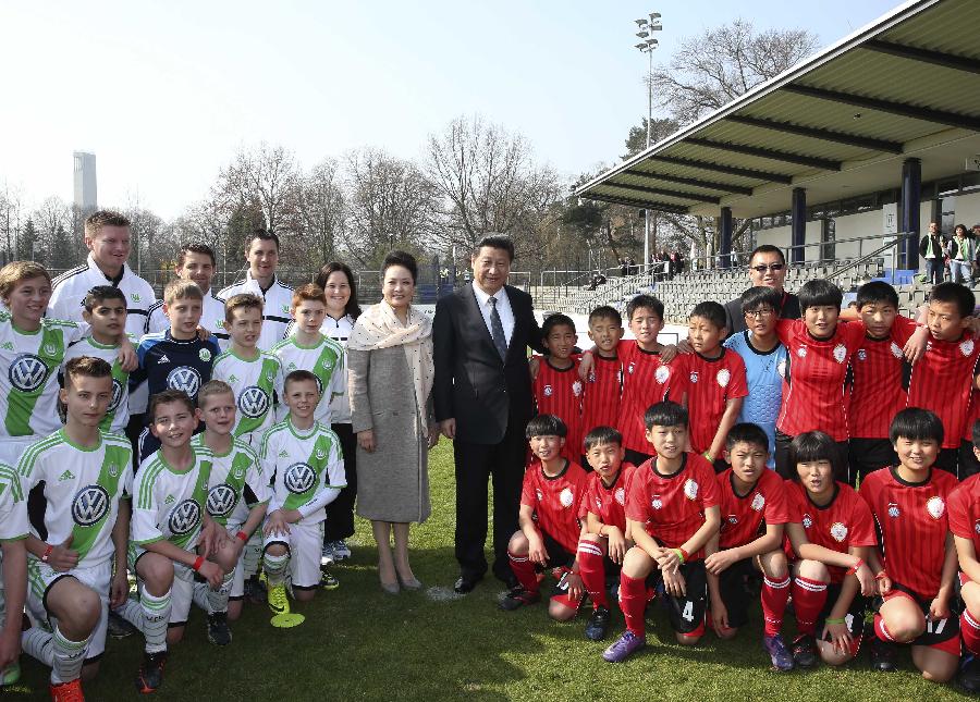 Chinese President Xi Jinping and his wife Peng Liyuan pose for a group photo with Chinese kid footballers and their German peers from the Wolfsburg club in Berlin, Germany, March 29, 2014. (Xinhua/Lan Hongguang)